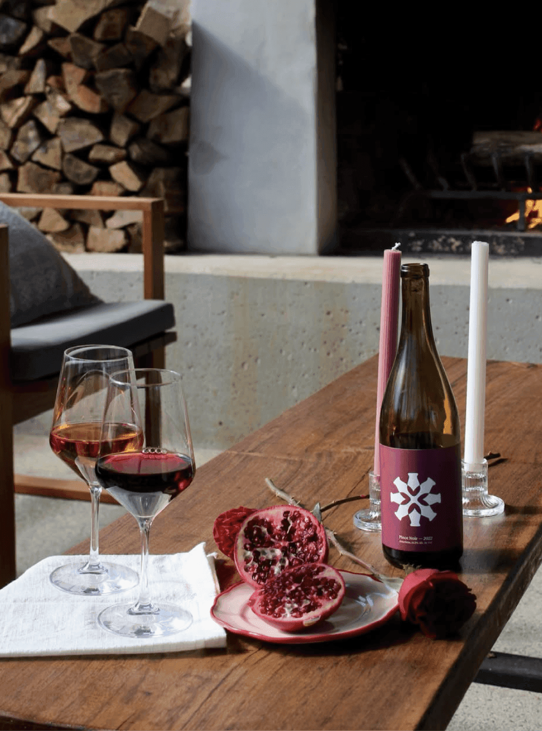 Doghobble Wine Farm Pinot Noir Bottle Setting. A Doghobble Wine Farm Pinot Noir bottle styled with pomegranates and candles for a warm, intimate tasting mood.