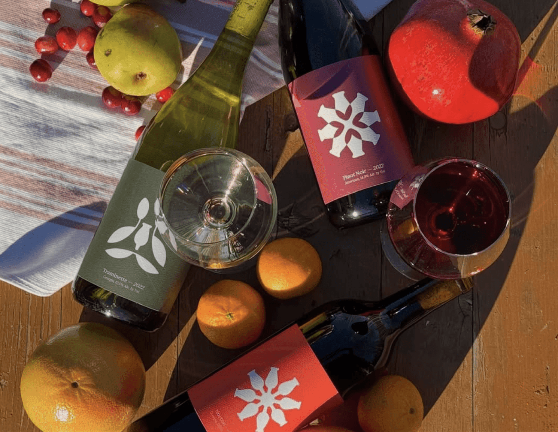 Doghobble Wine Farm Wine Trio. Doghobble Wine Farm bottles photographed with citrus and fruit in warm afternoon light.