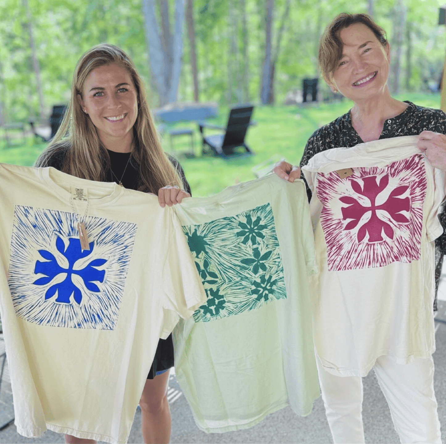 Doghobble Wine Farm Screen-Printed Shirts. Guests holding screen-printed shirts featuring bold Doghobble Wine Farm botanical icons.