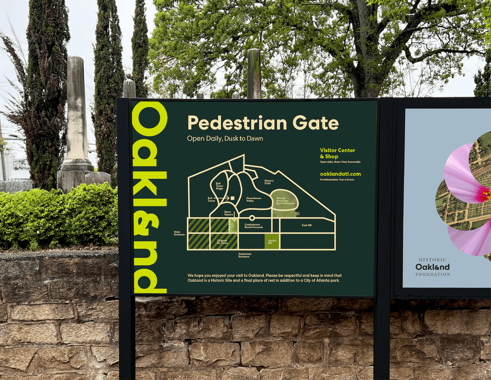 Exterior Oakland Cemetery signage displays the Pedestrian Gate map, wayfinding information, and bold vertical Oakland branding against a cemetery backdrop.